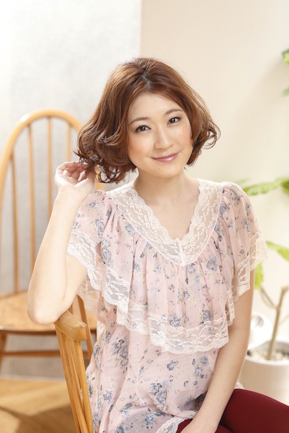 髪に手を当ててるボブスタイルの女性