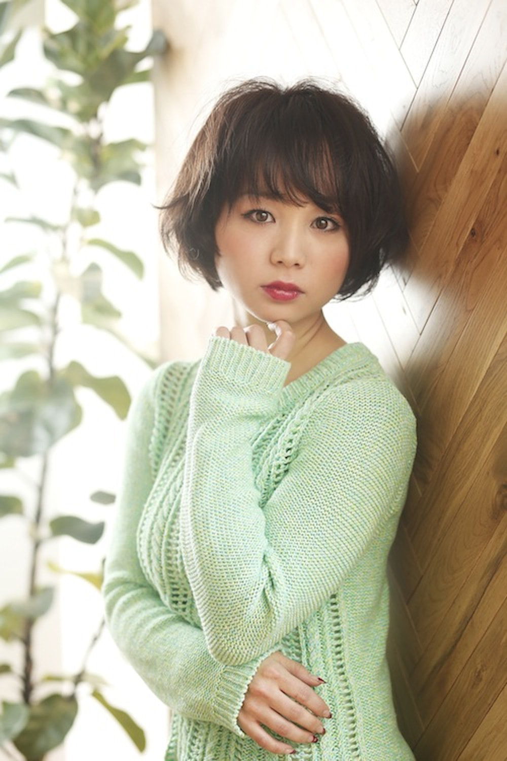 顎に手をかけるショートボブスタイルの女性