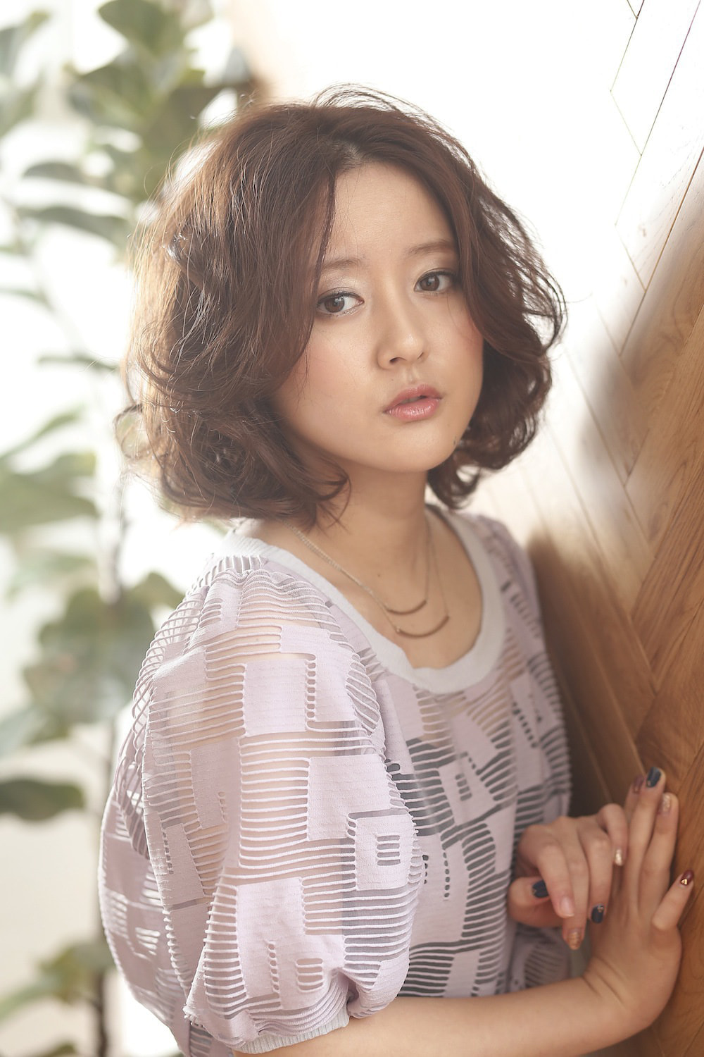 右斜め前を向いているボブパーマヘアの女性