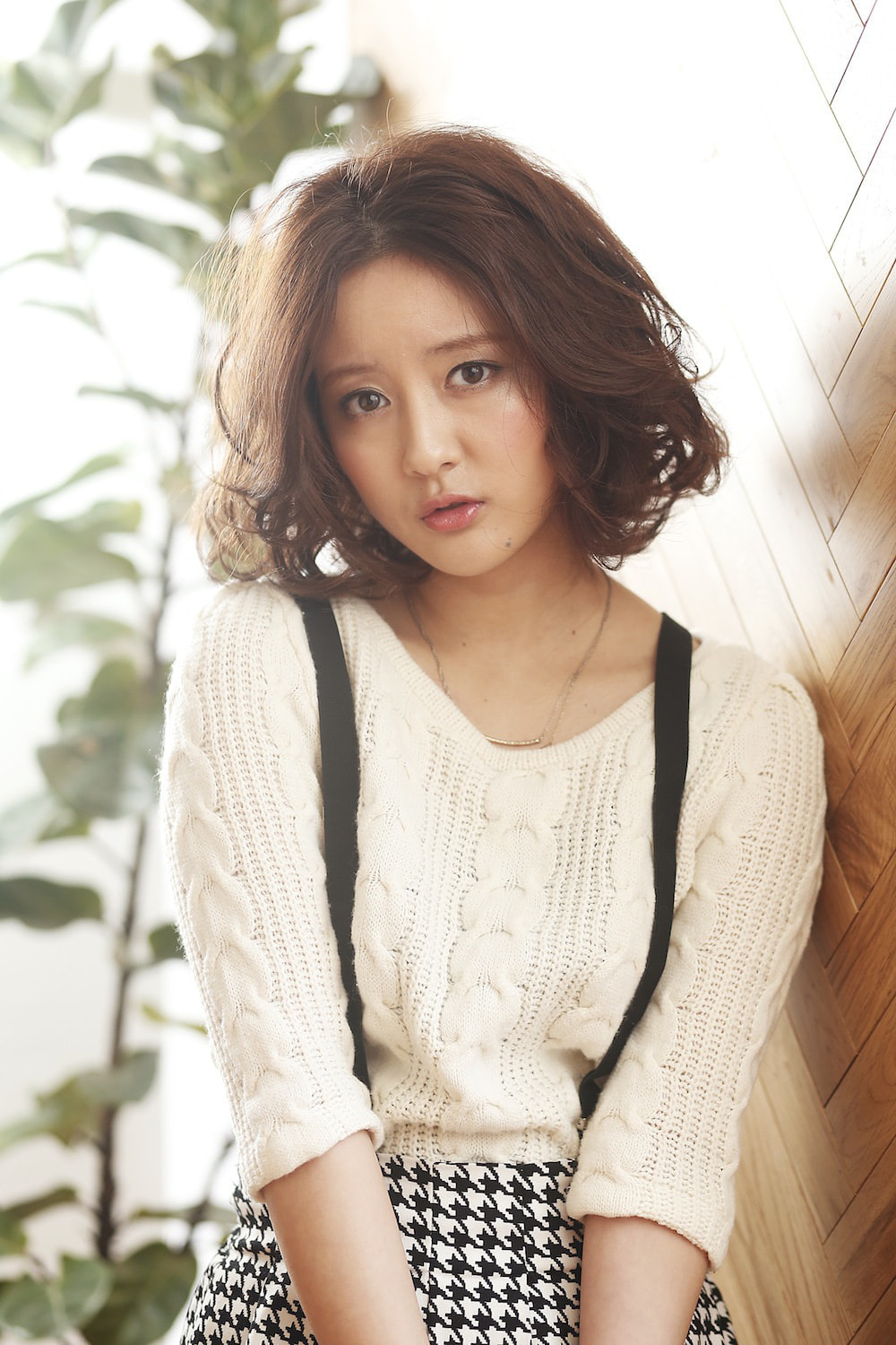 正面を向いているボブパーマスタイルの女性