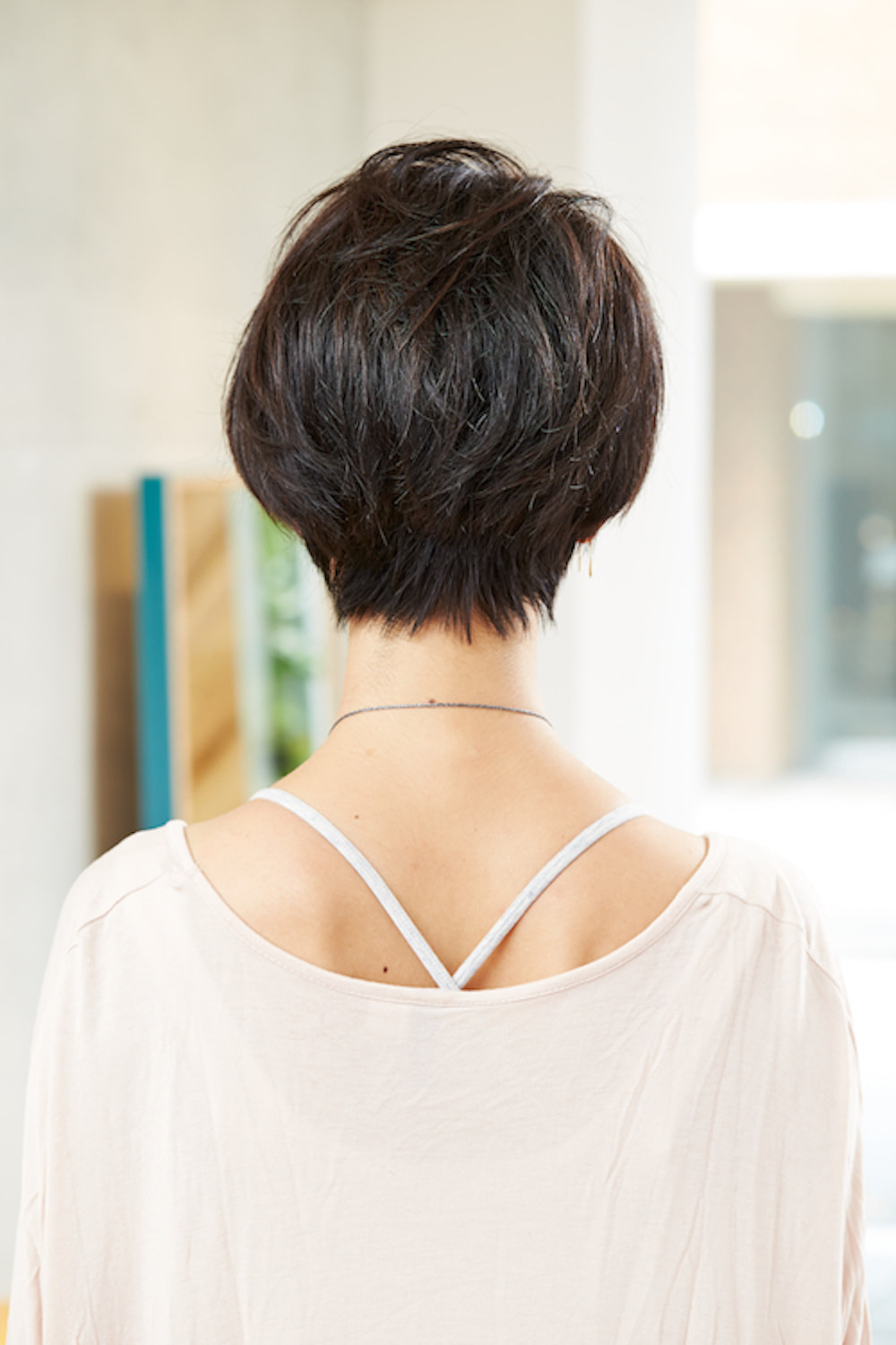 後ろ姿の黒髪ショートヘアの女性