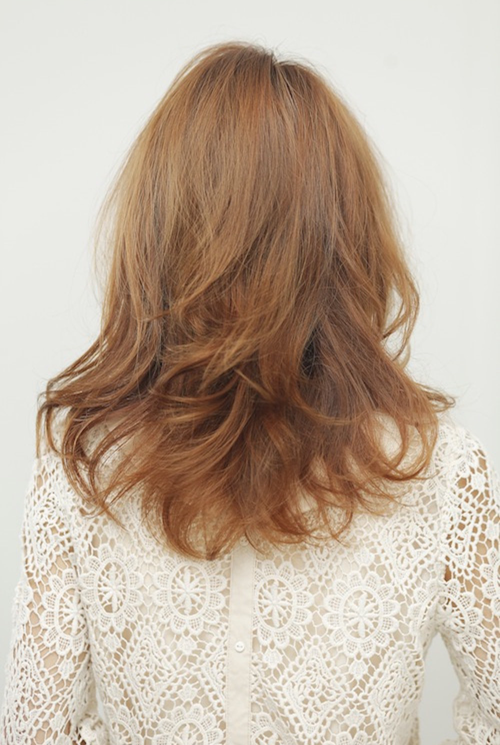 後ろ向の愛されミディアムヘアの女性