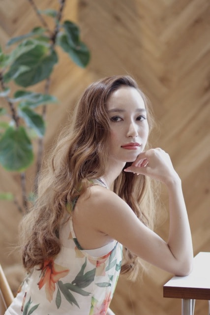 顎に手を当てたロングウェーブヘア