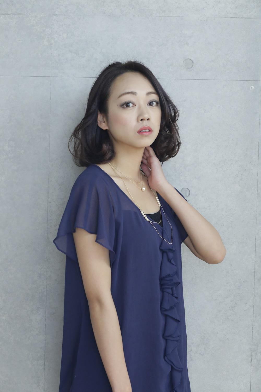 首に手をかけたボブスタイルの女性