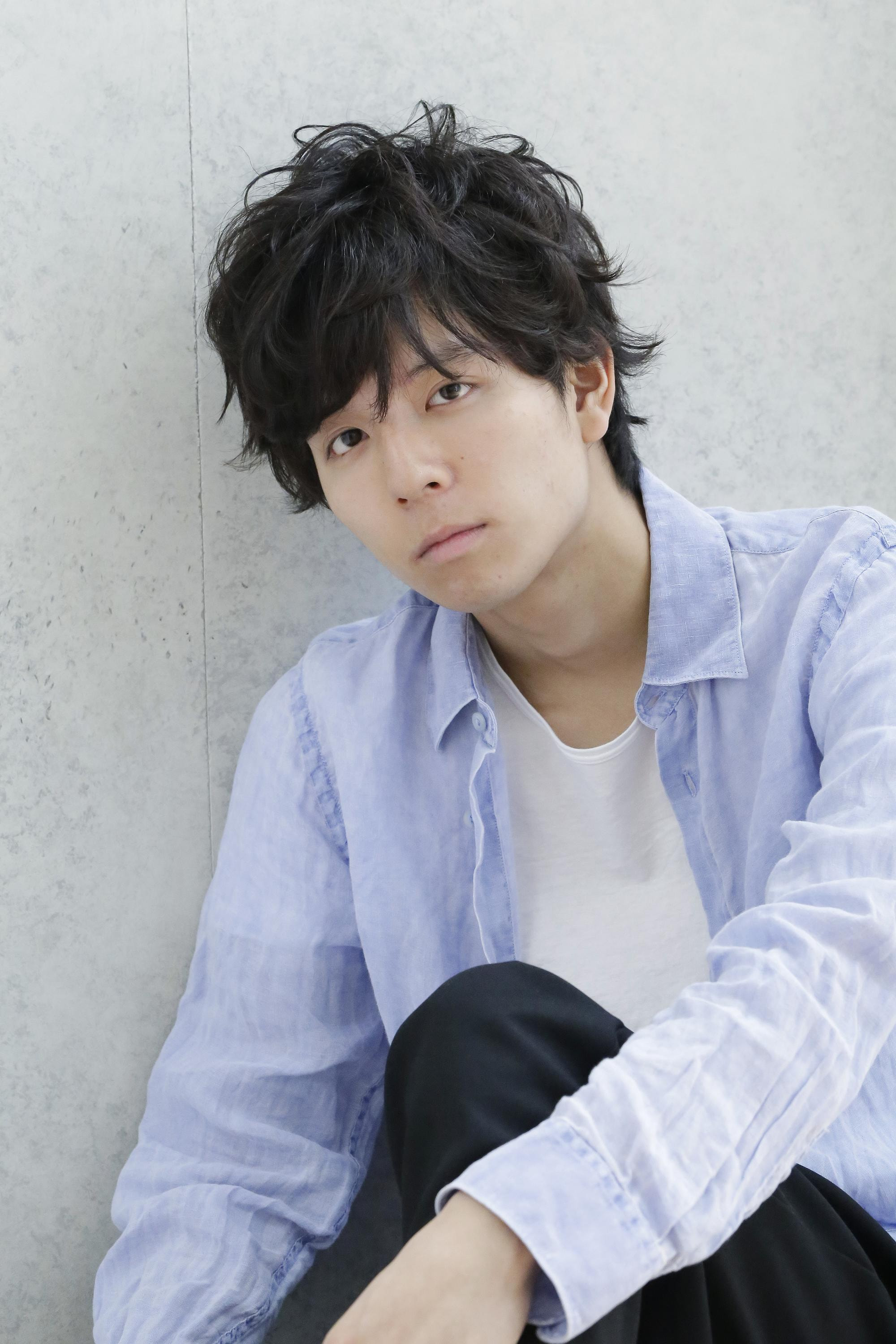 パーマスタイルの男性（足組）