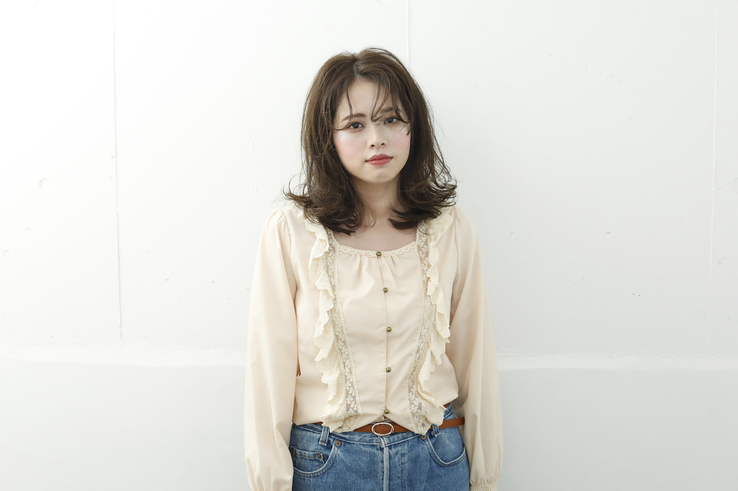 正面に立つ、くせ毛前髪の女性