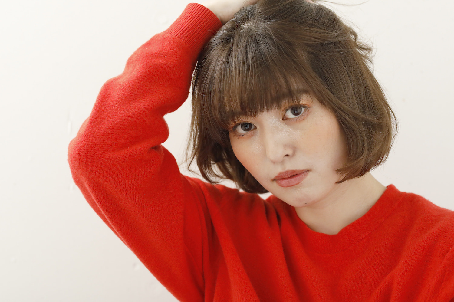 ふんわりミニボブの女性（頭に右手のせてる）