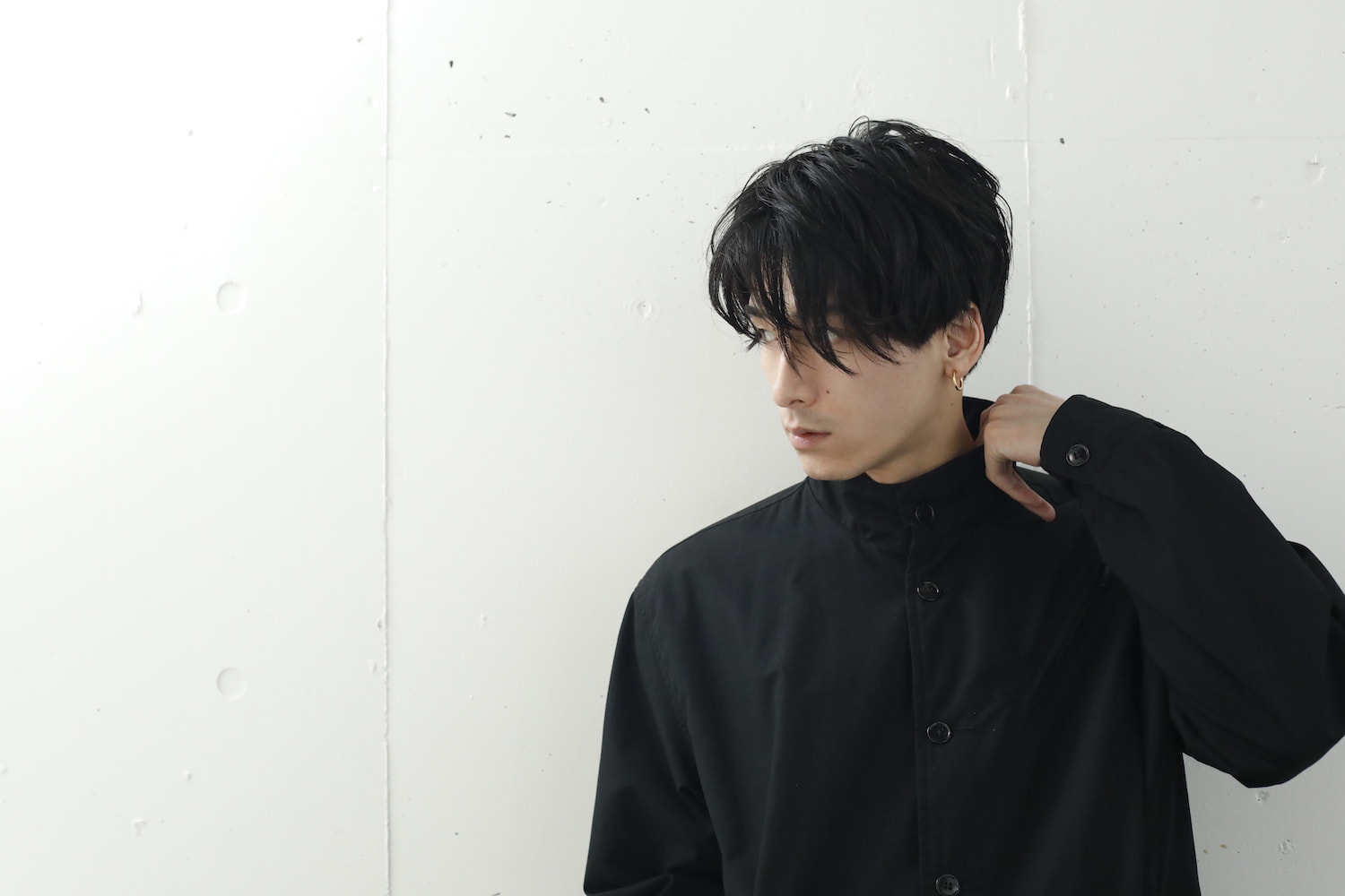 横を向いているセンターパートの黒髪男性