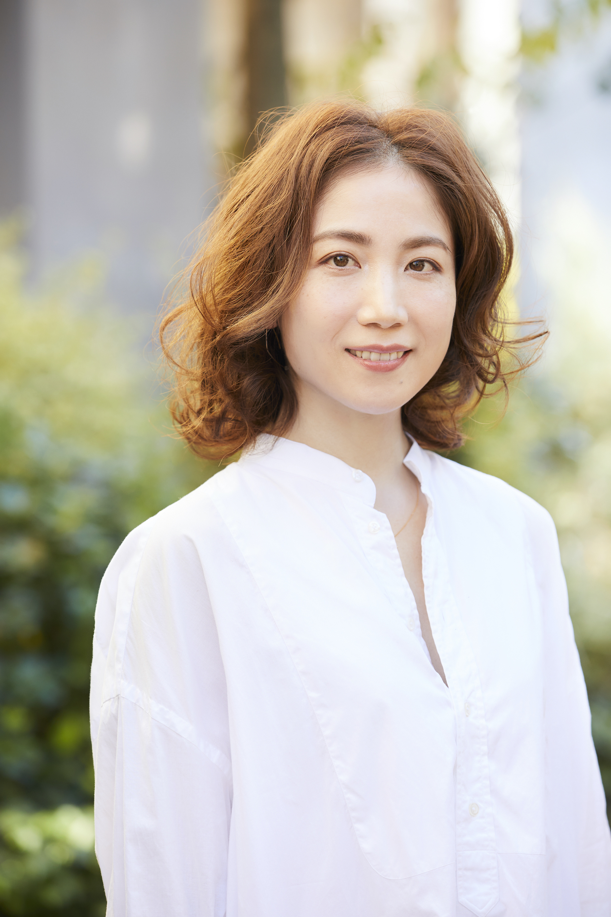 大人のこなれ感あるナチュラルフェミニンの女性（屋外での撮影）